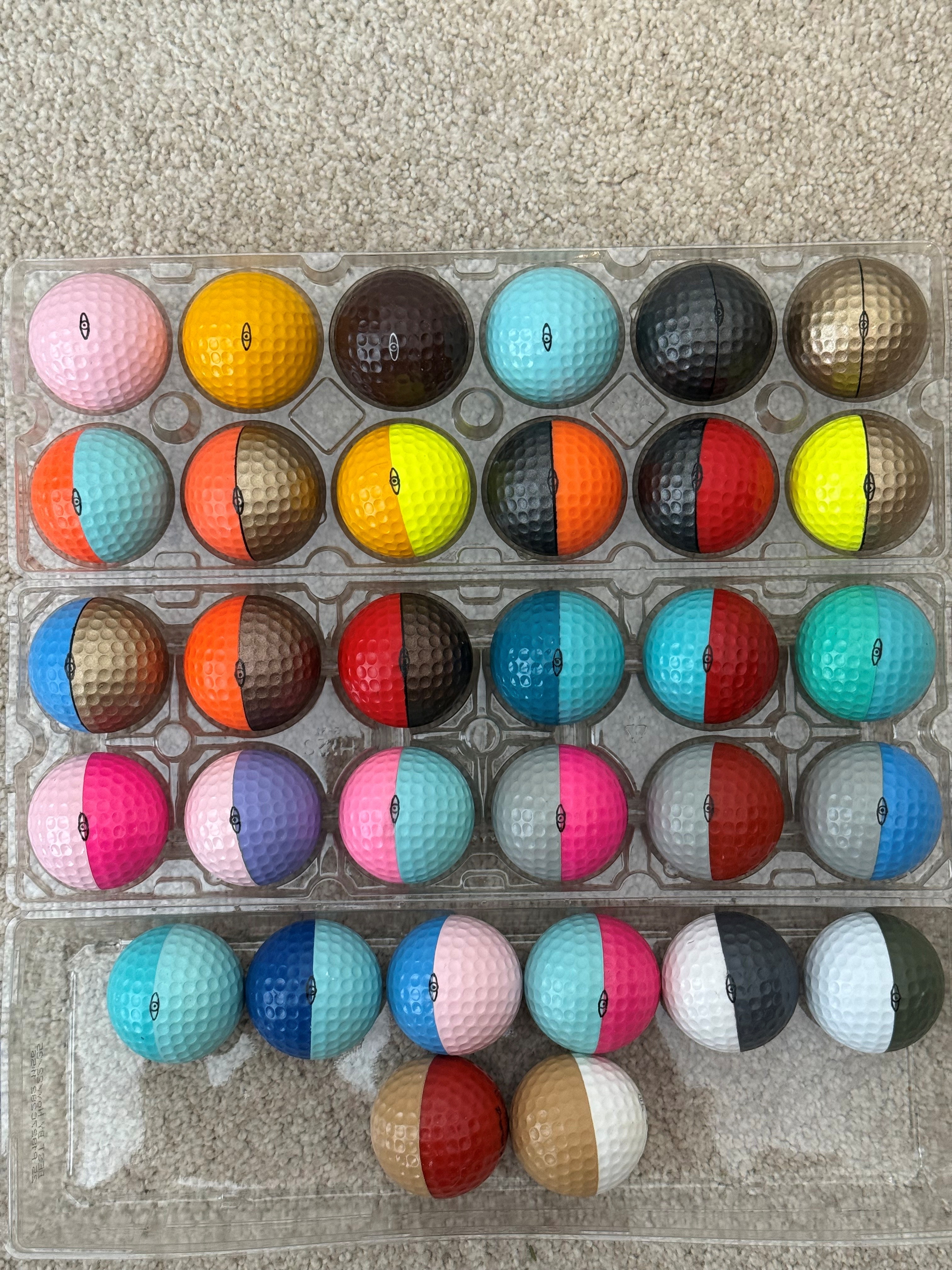 Rare rejected Ping golf balls from factory tours showing unusual color combinations in egg carton trays